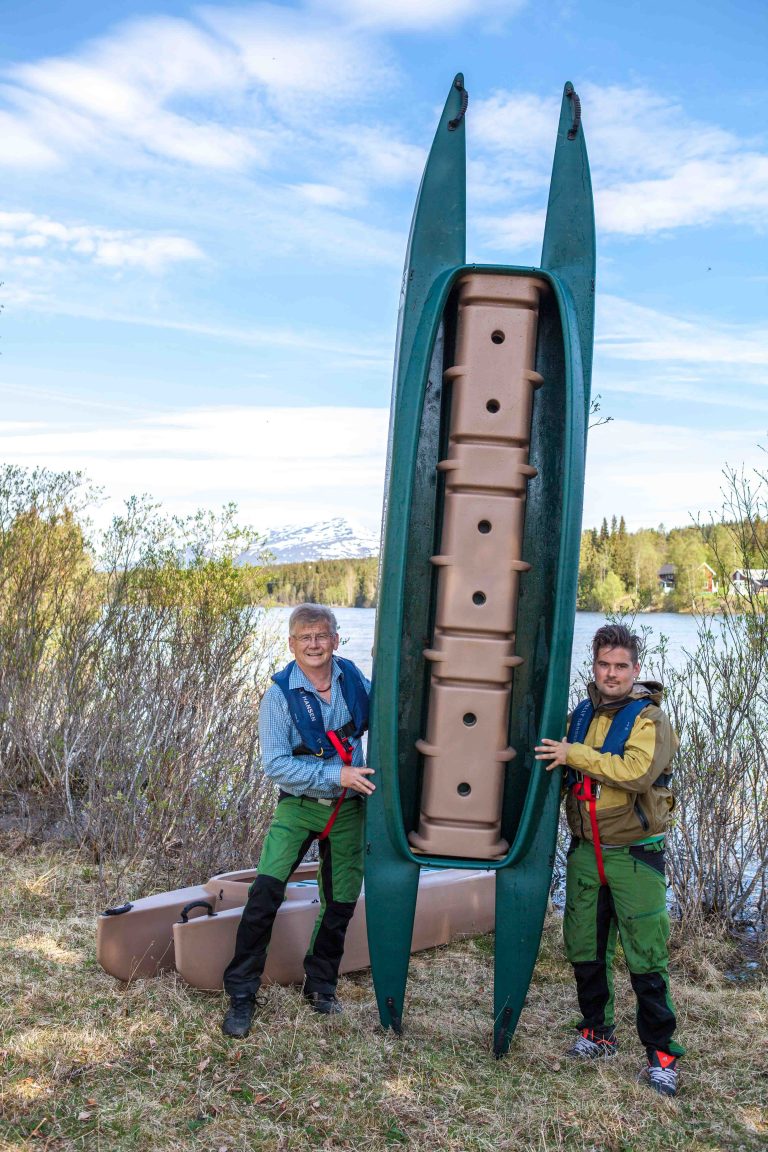 Two kayakers holding their Wavewalk 700 tandem kayak