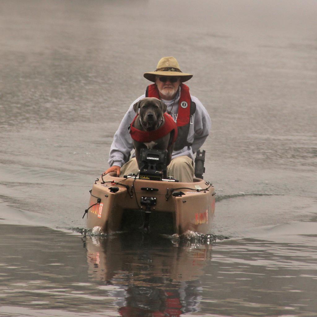 fisherman-driving-electric-fishing-kayak-with-dog-on-board-02-1024
