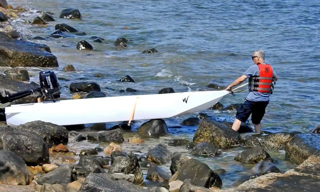 launching an ultralight skiff in a rocky beach