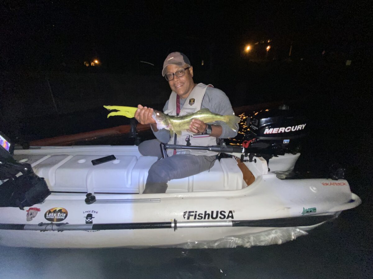 kayak angler showing a fish he caught in lake Erie