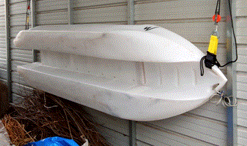 S4 microskiff stored on its side hanging on a carport wall