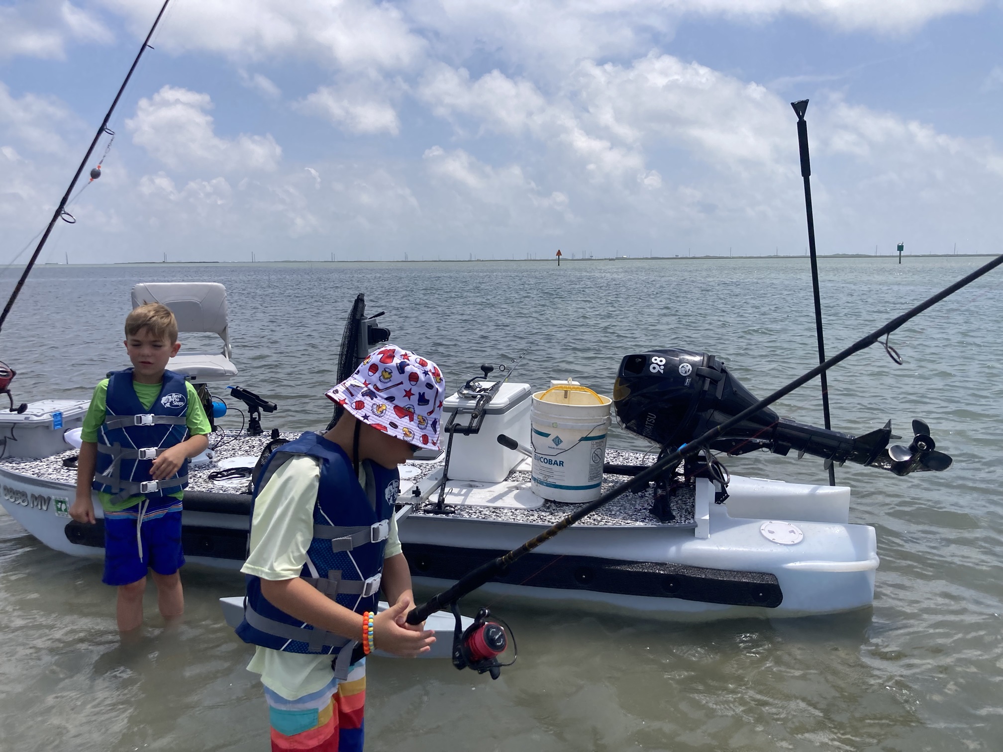 Kids fishing next to an S4 Microskiff